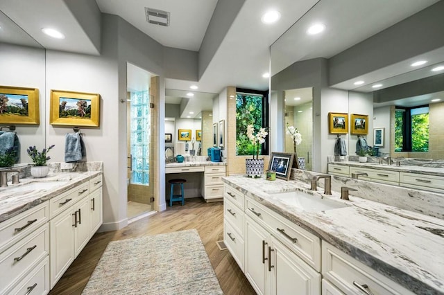 bathroom with walk in shower, vanity, and hardwood / wood-style flooring