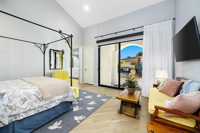 bedroom featuring access to outside, light hardwood / wood-style flooring, connected bathroom, and high vaulted ceiling