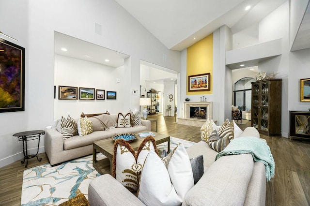 living room with high vaulted ceiling and hardwood / wood-style flooring