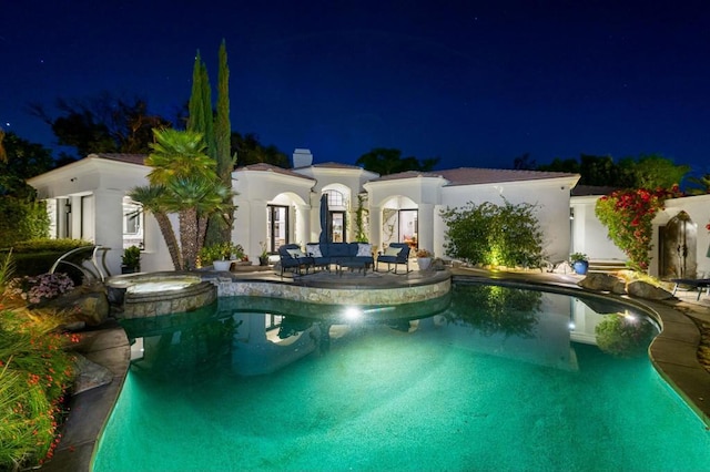 pool at twilight featuring an in ground hot tub and a patio