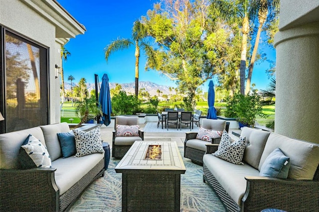 view of patio with an outdoor living space with a fire pit and a mountain view