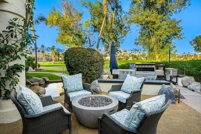 view of patio with area for grilling and an outdoor living space with a fire pit