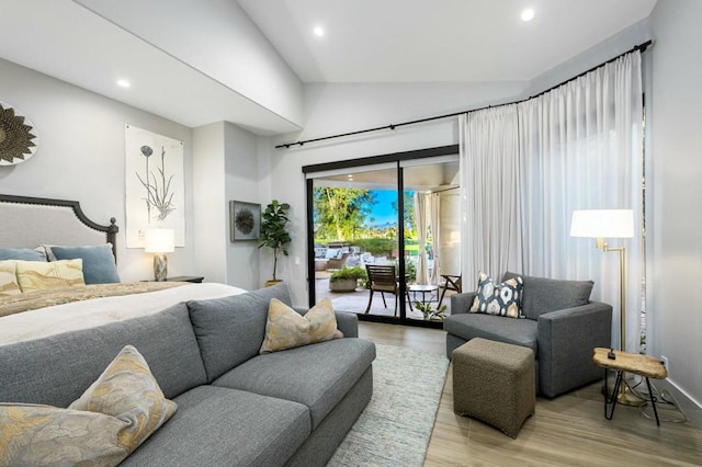 bedroom featuring vaulted ceiling, access to exterior, and light hardwood / wood-style floors