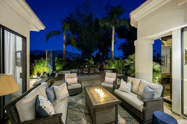 patio at night featuring an outdoor living space with a fire pit