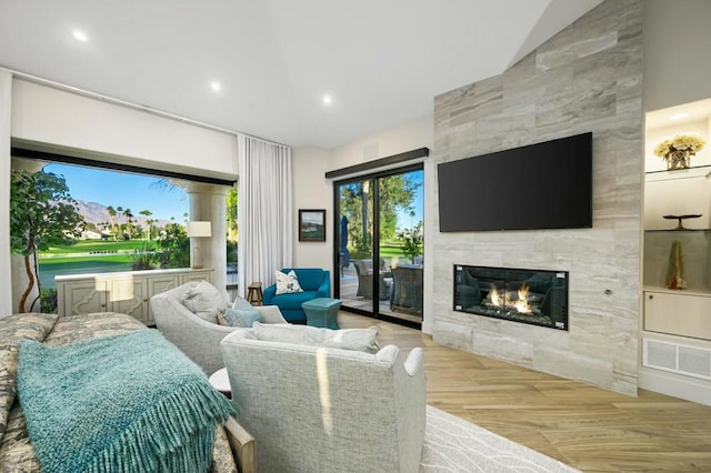 living room featuring a tiled fireplace and light hardwood / wood-style flooring