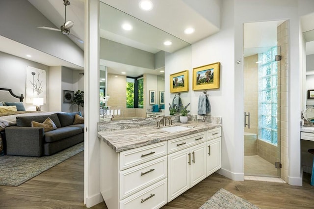 bathroom with walk in shower, vanity, ceiling fan, and hardwood / wood-style floors