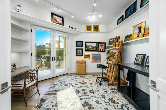 office space featuring rail lighting, french doors, and hardwood / wood-style flooring