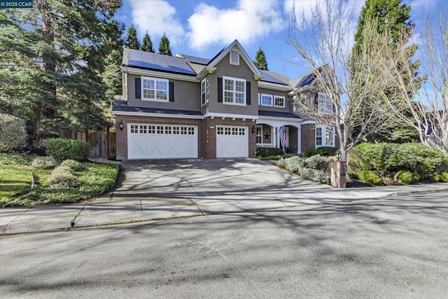 view of front of property with solar panels and a garage