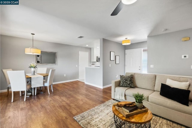 living room featuring ceiling fan and wood-type flooring