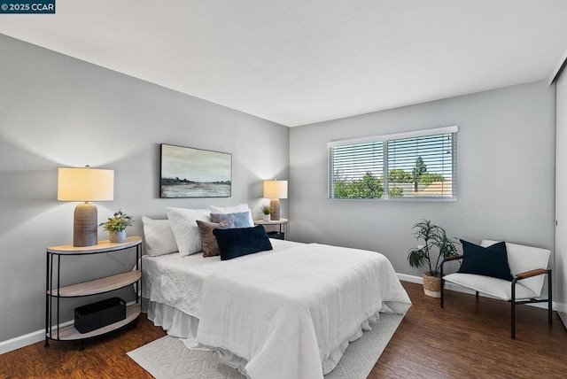 bedroom with dark hardwood / wood-style flooring