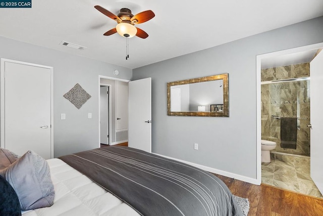 bedroom with ceiling fan, ensuite bathroom, and dark hardwood / wood-style floors