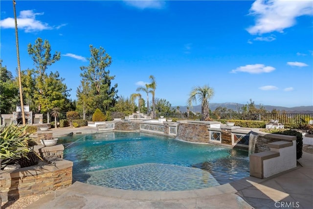 view of pool with pool water feature, a hot tub, a patio area, and a mountain view