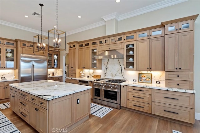 kitchen with backsplash, range hood, a kitchen island, and high quality appliances