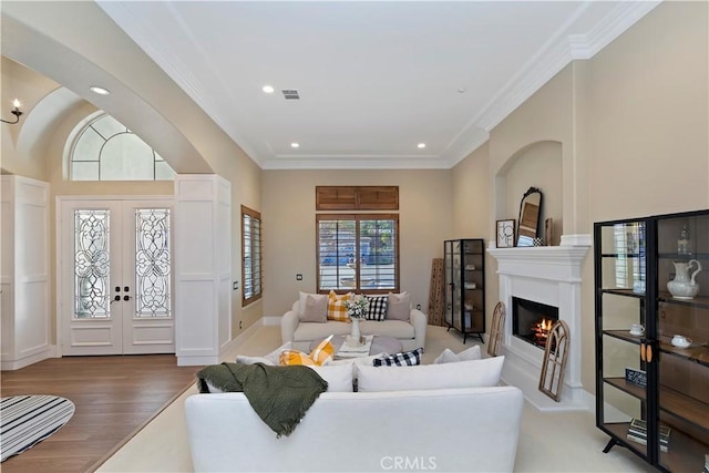 living room featuring hardwood / wood-style floors, ornamental molding, and french doors