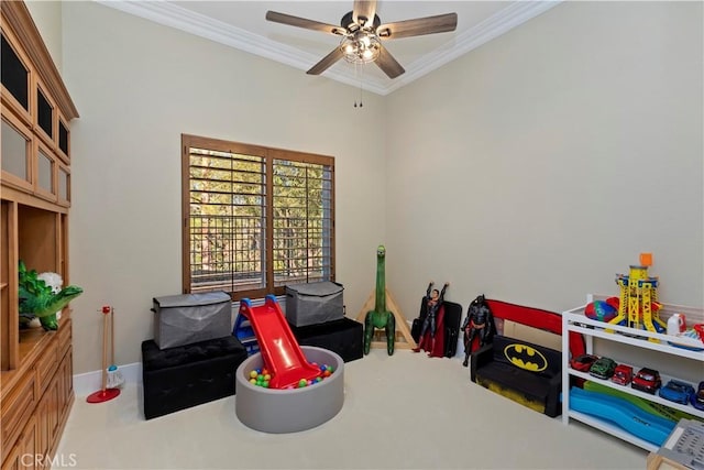 recreation room with ceiling fan, crown molding, and carpet flooring