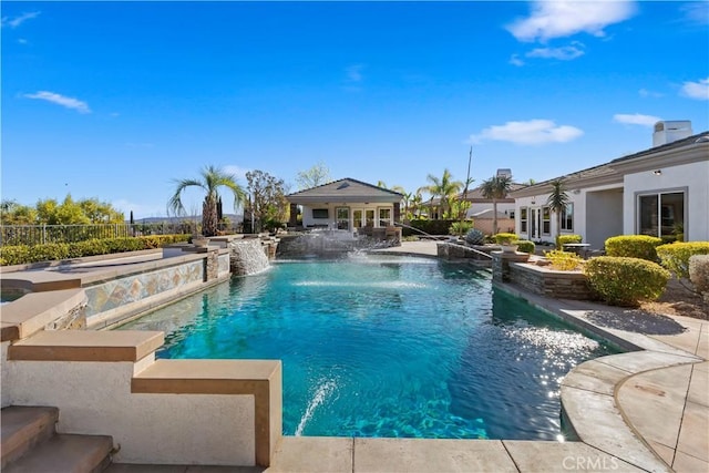 view of pool with pool water feature, a patio area, and an outbuilding