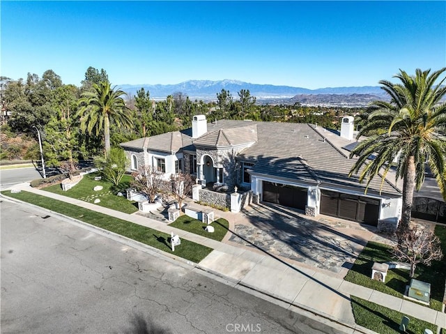 ranch-style home with a garage and a mountain view