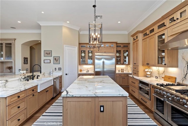 kitchen featuring decorative light fixtures, a kitchen island, decorative backsplash, ornamental molding, and high quality appliances