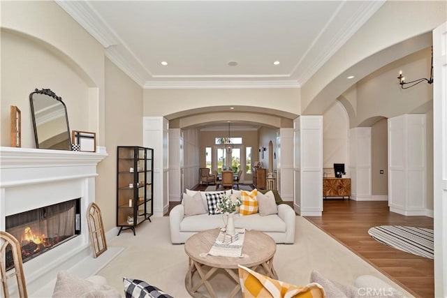 living room with a notable chandelier, crown molding, and hardwood / wood-style floors