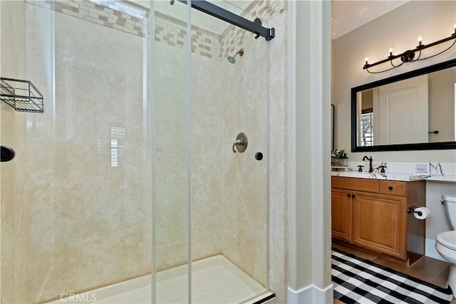 bathroom with an enclosed shower, vanity, and toilet