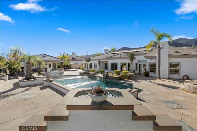 view of pool with an in ground hot tub, pool water feature, and a patio