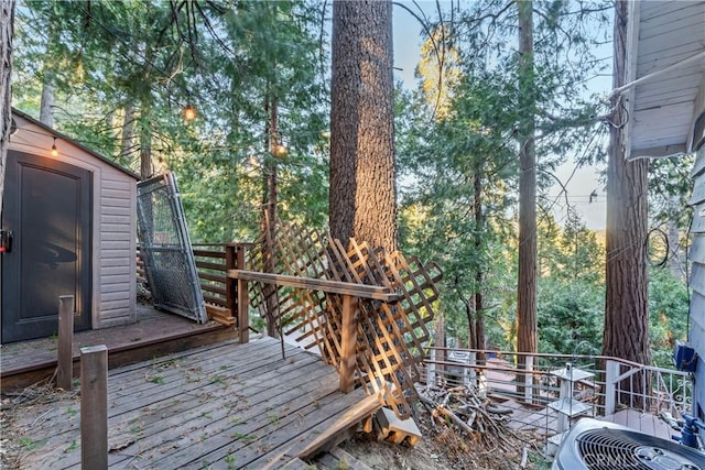 wooden deck featuring central AC and a storage shed