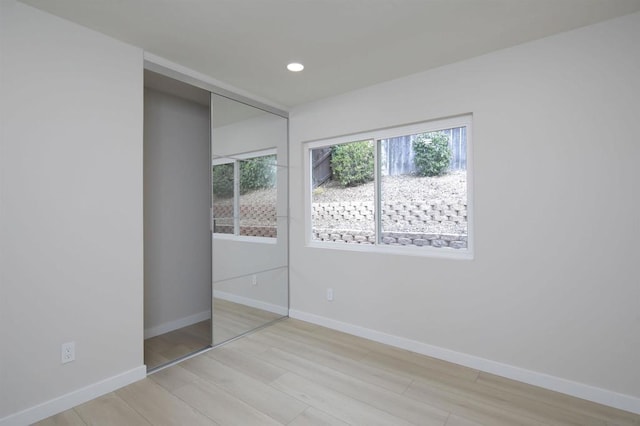 unfurnished bedroom featuring a closet and light hardwood / wood-style flooring