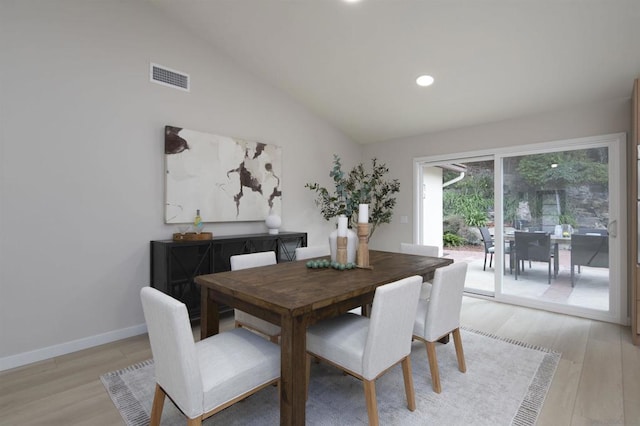 dining room with lofted ceiling and light hardwood / wood-style floors