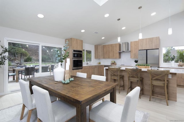 dining area featuring high vaulted ceiling and sink