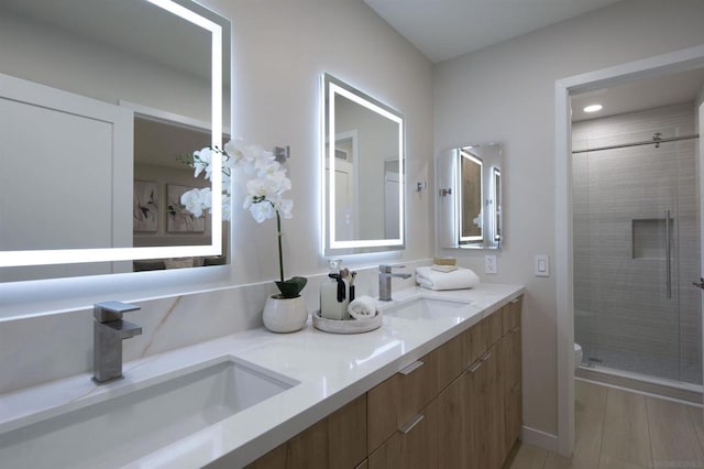 bathroom with toilet, a shower with door, and vanity