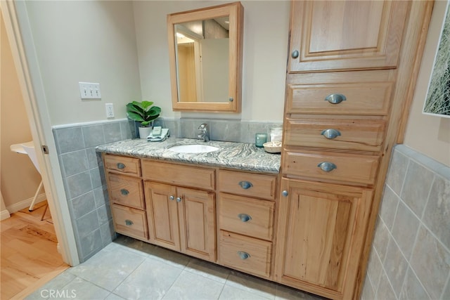 bathroom with tile walls, tile patterned floors, and vanity