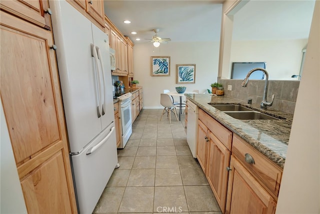 kitchen with white appliances, decorative backsplash, sink, ceiling fan, and light stone counters