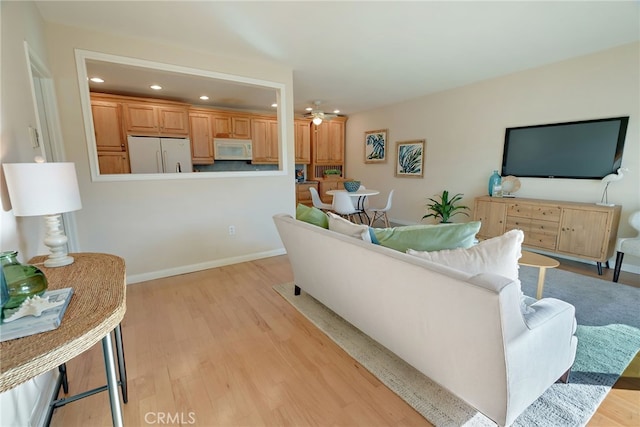 living room featuring ceiling fan and light hardwood / wood-style floors