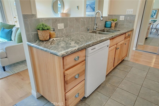 kitchen with backsplash, sink, white dishwasher, light tile patterned floors, and light brown cabinetry