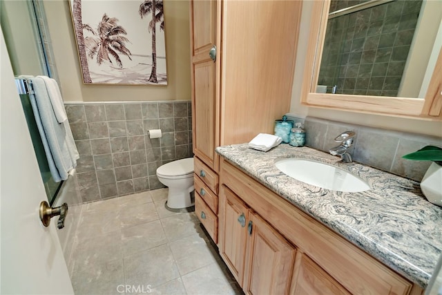 bathroom featuring toilet, tile walls, tile patterned floors, and vanity