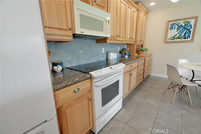 kitchen featuring decorative backsplash, white appliances, light tile patterned flooring, light brown cabinetry, and dark stone counters