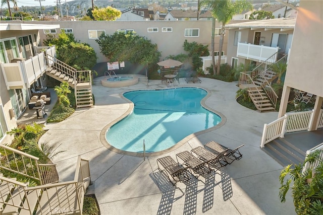 view of swimming pool featuring a hot tub and a patio