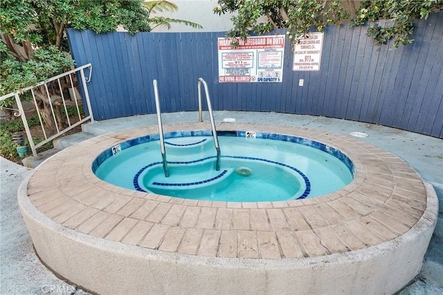 view of swimming pool with a hot tub