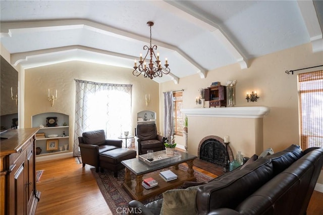 living room with vaulted ceiling with beams, built in features, an inviting chandelier, and hardwood / wood-style floors