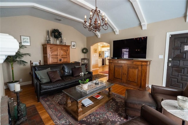 living room featuring dark hardwood / wood-style floors, lofted ceiling with beams, and a notable chandelier