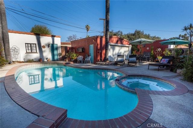 view of pool featuring an in ground hot tub and a patio