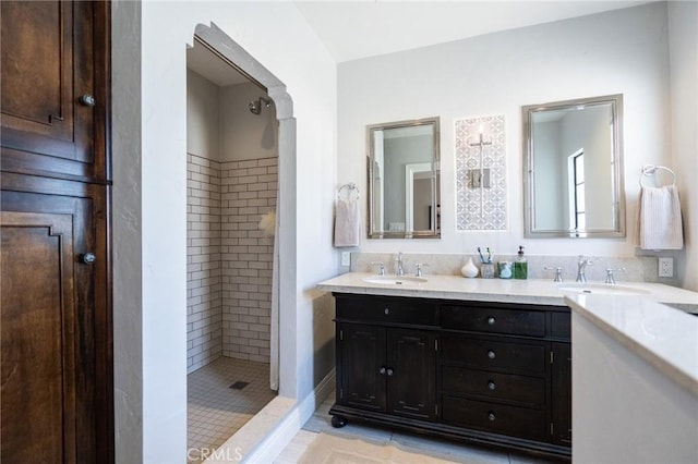 bathroom with a tile shower, tile patterned floors, and vanity