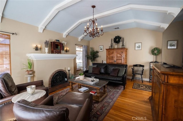 living room with a chandelier, light hardwood / wood-style flooring, and lofted ceiling with beams