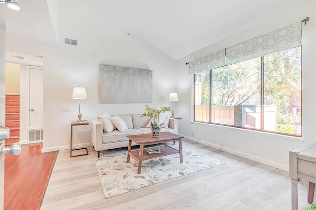 living room with vaulted ceiling and light hardwood / wood-style flooring