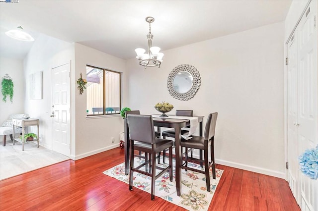 dining area featuring a notable chandelier and hardwood / wood-style flooring