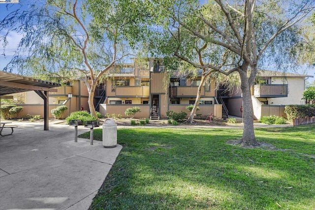 view of home's community featuring a pergola, a lawn, and a patio