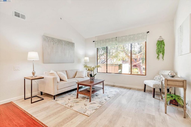 living room featuring light hardwood / wood-style floors and high vaulted ceiling