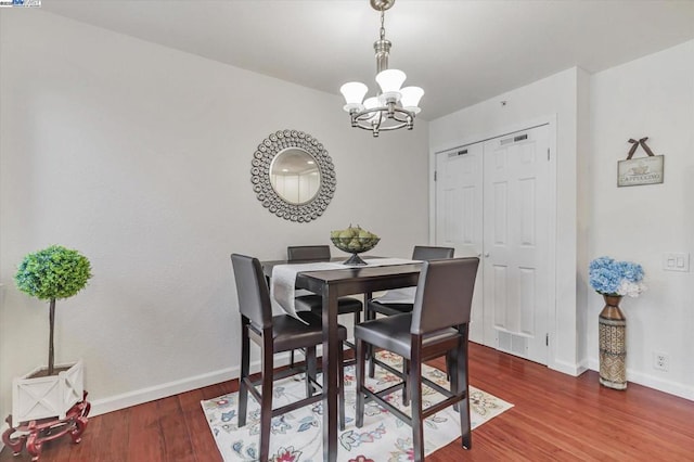 dining room featuring dark hardwood / wood-style flooring and an inviting chandelier