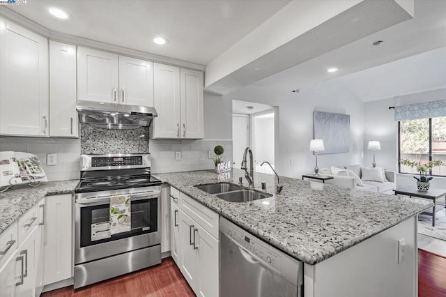 kitchen with sink, white cabinets, appliances with stainless steel finishes, and kitchen peninsula