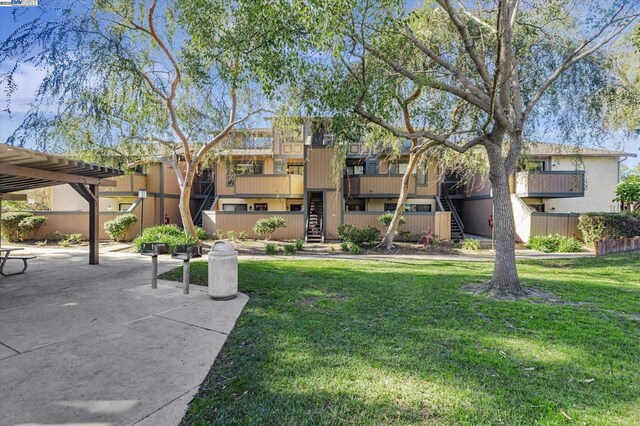 view of property's community with a patio area, a pergola, and a yard